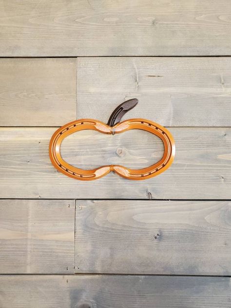 "Our beautiful horseshoe pumpkin wall hanging will be a simple addition to your fall decor! It is our traditional pumpkin with an orange body and a brown stem. It is a simple and affordable way to decorate any space, or it would make an excellent gift.  Get yours today!   WHAT YOU GET 1 - Horseshoe Pumpkin  DIMENSIONS  6.5\"h x 9\"w x 0.25\"d Everything we make is by hand which means there are no two products are identical (can vary up to 1\").   HOW ITS MADE    We use real horseshoes to give it Horseshoe Pumpkin, Pumpkin Wall Hanging, Halloween Pumpkin Decorations, Horseshoe Crafts Projects, Pumpkin Wall, Traditional Pumpkin, Recycled Metal Art, Pumpkin Decorations, Wood River