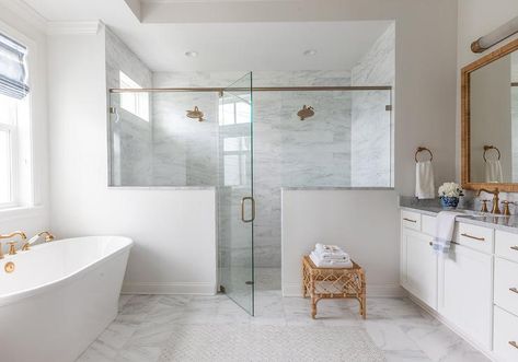 A glass shower door opens to a walk-in shower for two boasting two side-by-side aged brass vintage-style shower heads fixed to a marble slab surround. Rustic Tile Shower Ideas, Double Shower Head Master Baths, Master Shower Ideas, Shower Ideas Bathroom, Two Person Shower, Half Wall Shower, Transitional Bathroom Design, Double Shower Heads, Walk In Shower Ideas