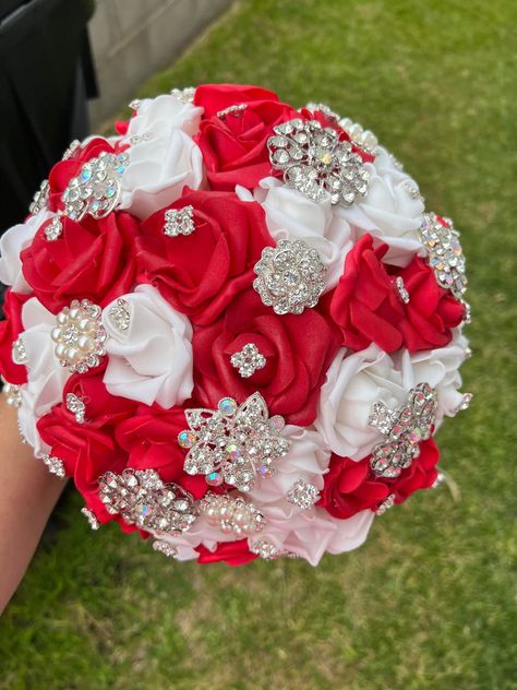 Handmade Quinceañera Bouquet/ Wedding. With Red and White Foamy Roses. Finished off with Silver brooches. *Please note brooches can change in style due to availability.* Decor / color combinations can be changed upon request. {This is a made to order Bouquet} Red And White Quince Bouquet, Red And Silver Flower Bouquet, Red Silver And White Wedding, Red White And Silver Quinceanera, Red Silver Wedding Theme, Red And White Quinceanera Decorations, Red And Silver Bouquet, Bridal Bouquet Red And White, Wedding Flowers Red And White