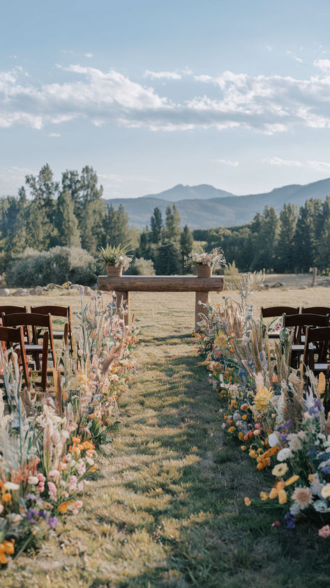 A wedding aisle beautifully lined with diverse, colorful wildflowers, leading to an outdoor ceremony. Wedding Aesthetic Garden, May Wildflower Wedding, Indoor Aisle Decor, Summer Wedding Colors Wildflowers, Wildflower Wedding Diy, Wildflower Rustic Wedding Theme, Wildflower Wedding Aisle Decorations, Sunset Color Flower Arrangements, Wildflower Inspired Wedding