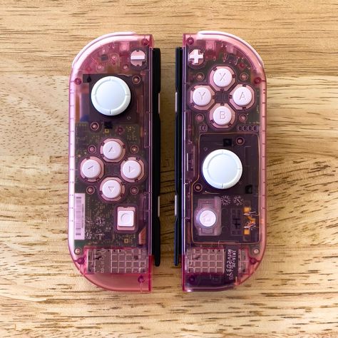 Clear pink Joycons for the Nintendo Switch with white buttons. Custom Nintendo Switch Joy Cons, Nintendo Switch Customization, Custom Joycons, Custom Nintendo Switch, Switch Controllers, Pink Switch, Hello Kitty Games, Gaming Nostalgia, Switch Board