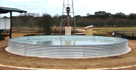 This bottomless stock tank has a concrete pad poured in and around the edge to create a water barrier against the ground.. Water Trough Pool, Round Stock Tank, Poly Stock Tank, Large Stock Tank, Stock Tank Swimming Pool, Tank Swimming Pool, Cowboy Pool, Diy Stock Tank, Stock Tank Pool Diy