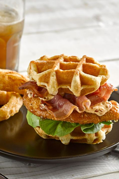 A fried chicken waffle burger on a dish on a white wooden table next to a beer glass. Chicken Burger Sauce, Waffle Burger, Brioche Recipes, Fried Chicken Waffles, Fried Chicken Burger, Traditional French Recipes, Burger Bun, Chicken Waffles, Fried Chicken And Waffles