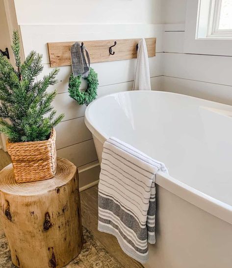 Every bathroom needs a freestanding bathtub for unwinding at night. This tub is accompanied by a wood and black metal towel rack mounted to a white shiplap surround. Decorate your bath for Christmas with small pine trees, a wooden log end table, and a small wreath. Decorating Bathroom Ideas, Oakstone Homes, Diy Crafts Desk, Bathroom Design Ideas Modern, Small Bathroom Ideas Decorating, Ranch House Remodel, Modern Bathroom Ideas, Remodel Small Bathroom, Housewarming Gift Ideas