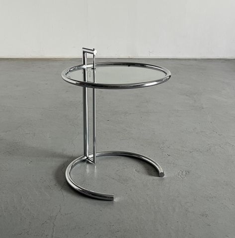 Vintage mid-century modern side table in the style of Eileen Gray's iconic "E1027" design.  Featuring a chromed steel frame and glass tabletop. Produced in Italy in the 1990s.  In very good condition with minimal expected signs of age. Width: 51 cm / 20.1 inches Depth: 51 cm / 20.1 inches Height: 62.5 cm / 24.6 inches Weight: 6 kg / 13.2 lbs   We try our best to accurately depict any imperfections on our photos. Please feel free to contact us for any additional photos. PACKAGING All of our items Chrome Side Table, Mid Century Modern Side Table, Glass Side Table, Big Sofas, Glass Side Tables, Grey Table, Adjustable Height Table, Kitchen Dining Tables, Modern Side Table