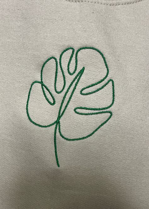 Photo features: Tan Sweatshirt x Green Thread ✰Embroidered, half of a set✰UNISEX✰Hand drawn and designed✰Super soft and comfy! Materials: 50/50 cotton poly blend *Sizes 2XL-3XL may be subject to longer processing times since we don't carry a large amount of inventory in those sizes, so we would have to put in a special order from our supplier! Thank you for understanding. Monstera Leaf Embroidery Pattern, Embroidery Plants Leaves, Green Embroidery Design, Laurel Embroidery, Plant Embroidery Pattern, Monstera Embroidery, Hoodie Outline, Olive Embroidery, Moss Embroidery