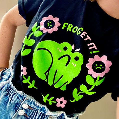 FROG-ET IT!! In this two colour screen printed frog tee!  Available in unisex sizes S-XXL. Printed on black Gildan soft-style tees for extra comfort! Cute T-shirts, Screen Printing Ideas, Frog Fashion, Frog Outfit, Frog Tshirt, Black Frog, Frog Costume, Frog Shirt, Frog T Shirts