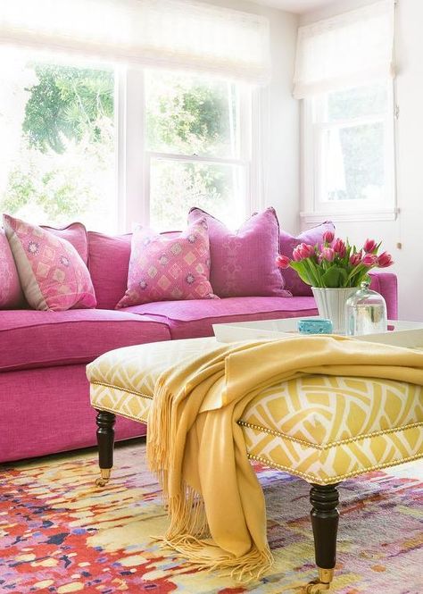 Packed with color, this contemporary living room fitted with a hot pink sofa topped with pink pillows and positioned beneath a windows accented with white roman shades. Pink Couch Living Room, Pink Sofa Living Room, Rosa Sofa, Yellow Decor Living Room, Pink Living Room Decor, Pink Couch, Pink Furniture, Living Room Decor Colors, Yellow Living Room