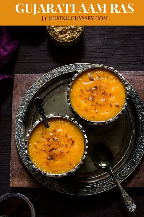 Tow aam ras bowls placed on a metal round tray next to ghee bowl