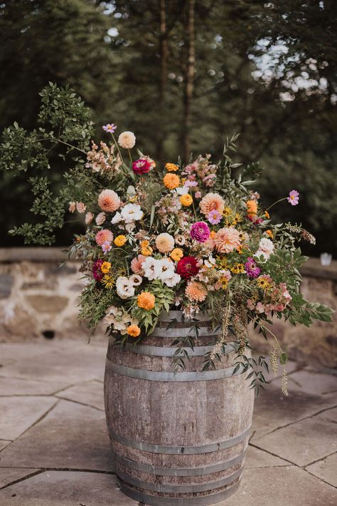 Bright pastels and wildflowers come together in perfect harmony at the Inn at Grace Winery wedding. The wedding features breathtaking floral designs that encapsulate the essence of a romantic vineyard wedding. Get inspired for your big day with florals that are as vibrant and joyful as your love story! Wedding Flowers On Barrels, Romantic Flowers Wedding, Country Wildflower Wedding, Texas Wildflower Wedding, Wildflower Floral Arrangements, Western Wildflower Wedding, Meadow Wedding Flowers, Vineyard Wedding Decorations, Wildflower Fall Wedding