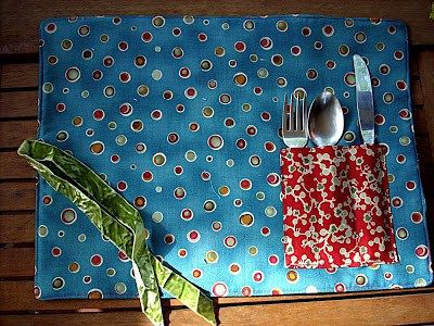 Materials 2 16′ x 10′ cotton fabric pieces 1 16′ x 10′ felt 1 4.5′ x 4.5′ cotton fabric for the pocket 18 ‘ matching ribbon Fold edges of pocket and top st… Fat Quarter Sewing Projects, Placemat Patterns, Placemats Patterns, Cutlery Holder, Mug Rug, Oil Cloth, Fabric Projects, Mug Rugs, Learn To Sew