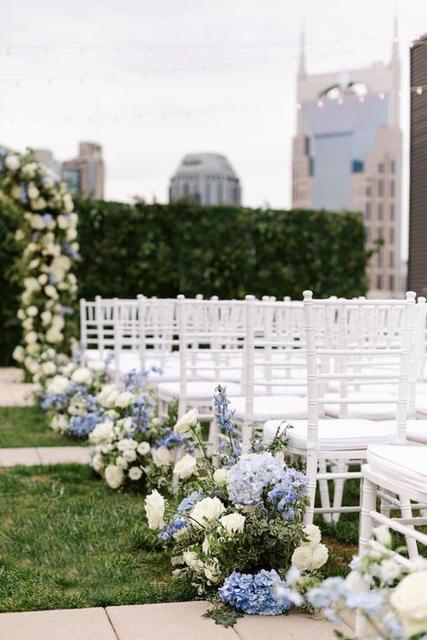 Wedding ceremony decorations for Kati & Bryant’s elegant Nashville wedding. We decorated their wedding ceremony with an elegant wedding arch, blue and white wedding flowers and hydrangeas, and white wedding chairs. Their beautiful light blue and white wedding color palette was perfect for their elegant wedding décor. We offer luxury wedding planning in Nashville and beyond. Nashville wedding venues Hydrangea Wedding Aisle, Hydrangea Wedding Ceremony, Light Blue And White Wedding, White Wedding Chairs, White Wedding Color Palette, Blue And White Hydrangea, White Hydrangea Wedding, Rooftop Wedding Ceremony, Blue Hydrangea Wedding