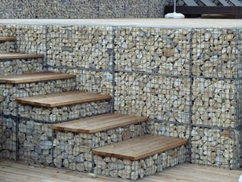 Gabion baskets are filled with rocks as steps and wall. Gabion Wall Design, Gabion Retaining Wall, Stone Walls Garden, Gabion Fence, Casa Hobbit, Gabion Baskets, Gabion Wall, Landscaping Retaining Walls, Garden Stairs