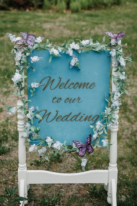 DIY blue wedding sign with floral detail | Outdoor Floral and Butterfly Themed Wedding | Candace and Alan completely planned and DIY'ed their wedding day and the end result was a stunning affair that represented who they are so perfectly! We love the colors they used as well as all of the butterfly details! | Browse Real Weddings on The Budget Savvy Bride | Greta Digiorgio Photography | Candace + AlanSouth Deerfield, Massachusetts - Total wedding budget $7,000 Butterfly Themed Wedding Ideas, Butterfly Wedding Theme Decoration, Fairy Garden Wedding Theme, Wedding Butterfly Theme, Blue Butterfly Wedding Theme, Purple Butterfly Wedding Theme, Wedding Butterfly Decorations, Butterfly Garden Wedding Theme, Butterfly Wedding Reception