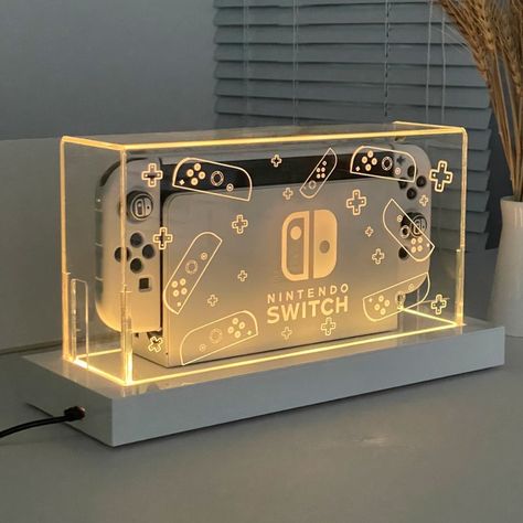 Keep Your Nintendo Switch Dock Clean and Shiny Introducing our crystal clear Acrylic dock cover - Dock Cover Pro™ the perfect accessory for Nintendo Switch and Switch OLED model users. This cover is specifically designed to fit your docked Switch and keep it dust-free, making your gaming area look top-notch. Our cover fits with room to spare over your Switch, including the joycons, providing ultimate protection against dust and scratches. The sturdy and durable material ensures that your dock st Nintendo Switch Dock, Gaming Area, Acrylic Display Box, Gamer Setup, Streaming Setup, Nintendo Switch Oled, Nintendo Switch Accessories, Gaming Room Setup, Pc Setup