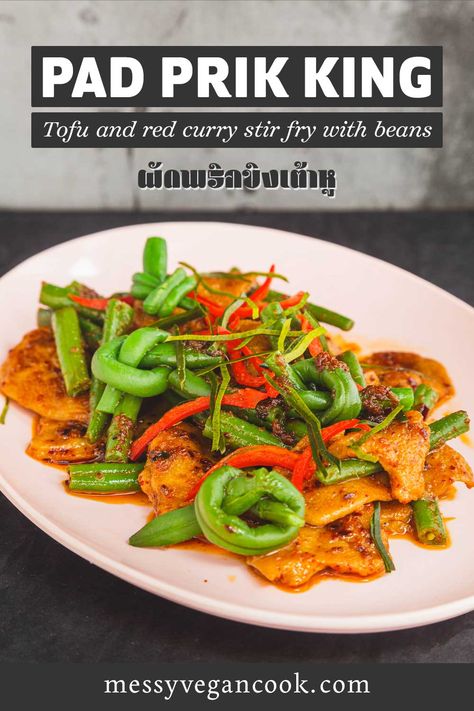 the image is taken at a slight angle from above. Light pink oval melamine plate on a black background. Plate contains thinly sliced pieces of seitan stir fried with long (green) beans. Some of the beans are tied into knots. Red oil pools around the plate. Prik Khing Recipe, Prik King Recipe, Pad Prik King Recipe, Pad Prik King, Pad Prik, Vegan Thai Curry, Thai Vegan, Thai Stir Fry, Foreign Food