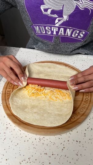 659K views · 5.6K reactions | Hot Dog Casserole | I found a new way to make hot dogs 😍 | By The Shaba Kitchen | Start by placing a hot dog in the center of a tortilla wrap. Then I'm going to take some shredded cheddar cheese and just add that on the side just like that. Then we're going to take the sides of our wrap. Fold them over onto our hot dog. And then we're just going to tuck and roll. And you should be left with something like this. Then we're going to place this in our casserole dish with the rest. Next I'm going to take some garlic butter. And then I'm just going to brush that on our tortilla wraps. Then we're just going to do a little bit on top of each one. Give it a little bit more flavor and help it get nice and crispy. Now it's time for a bit more cheese. I'm going to take Wrapped Hot Dogs Crescent, Keto Hot Dog Casserole, Tortilla Hot Dog Wraps, Leftover Hot Dogs, Hot Dog Wraps, Hotdogs Recipes, Mexican Hot Dogs, The Shaba Kitchen, Hot Dog Casserole