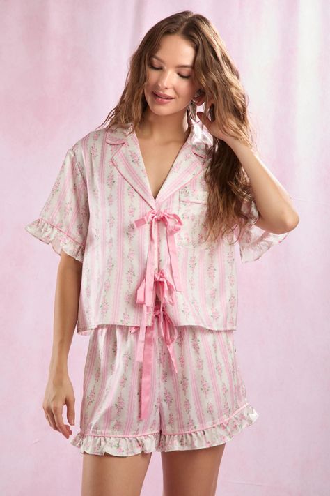 A charming pink and white pajama set with a floral stripe design. Featuring a satin ribbon-tie top with a notched collar and ruffled hem shorts, it's the perfect blend of comfort and vintage elegance. Size: The Model is Wearing a Size Small. (HEIGHT 5'9" / BUST: 30.5" / WAIST: 24" / HIPS: 34.5") Material: 100% Polyester Neckline: V Neck White Pajama Set, Pink Pajama Set, Spring Pajamas, Pink Pajama, Floral Pajama Set, White Pajamas, Pink Pajamas, Floral Pajamas, Vintage Elegance