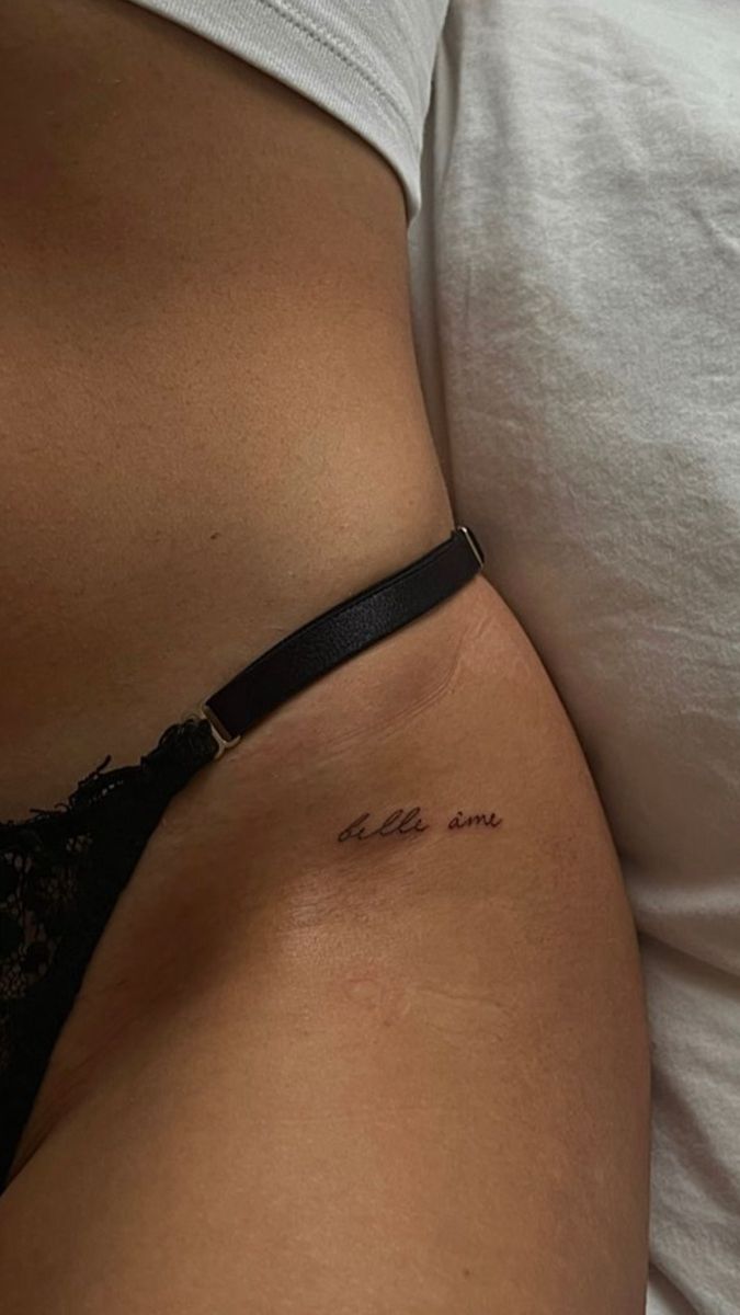 a woman's stomach with the word love written on it and a small tattoo