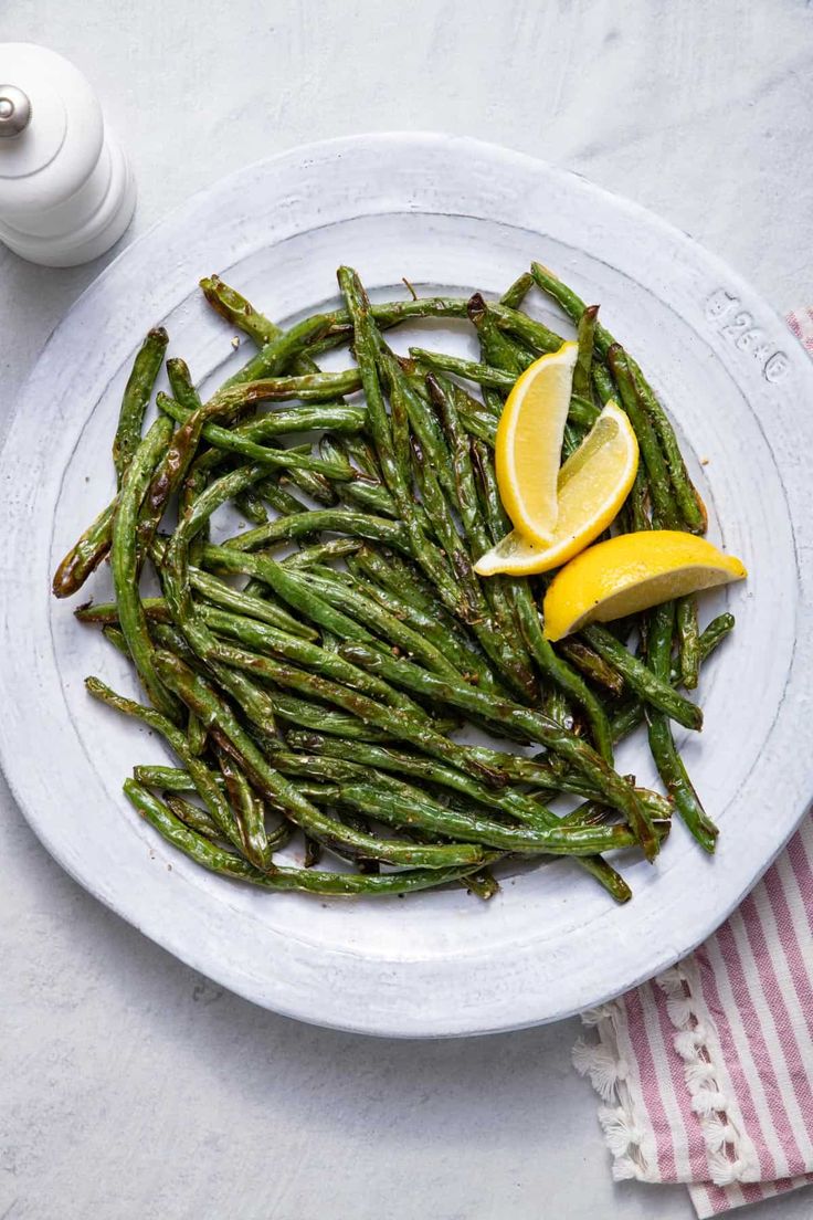 asparagus with lemon wedges on a white plate