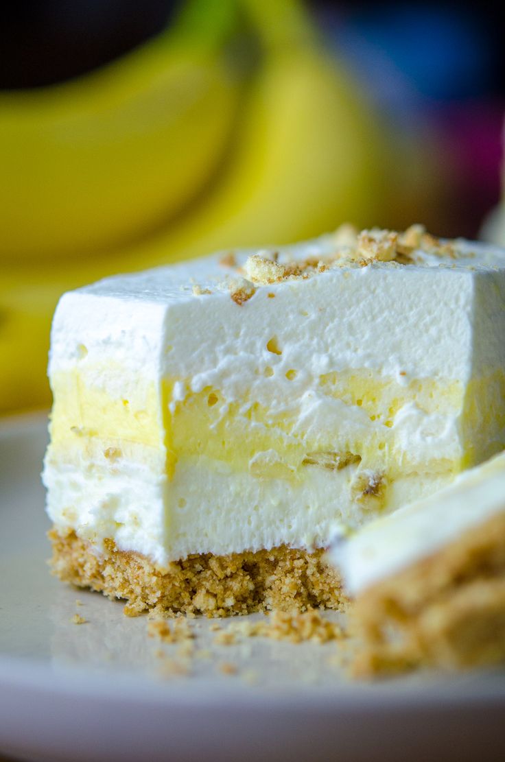 a piece of cheesecake on a plate with bananas in the background