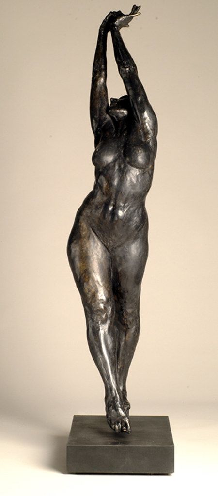 a bronze statue of a woman reaching up