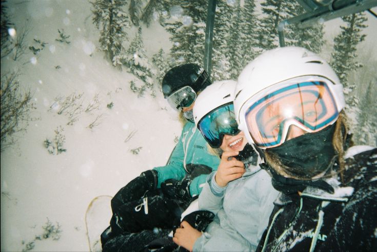 two people wearing skis and goggles standing in the snow