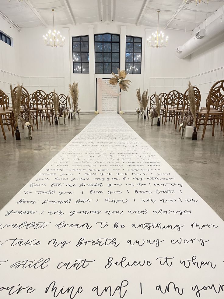 a large white sheet with writing on it in a room full of chairs and chandeliers