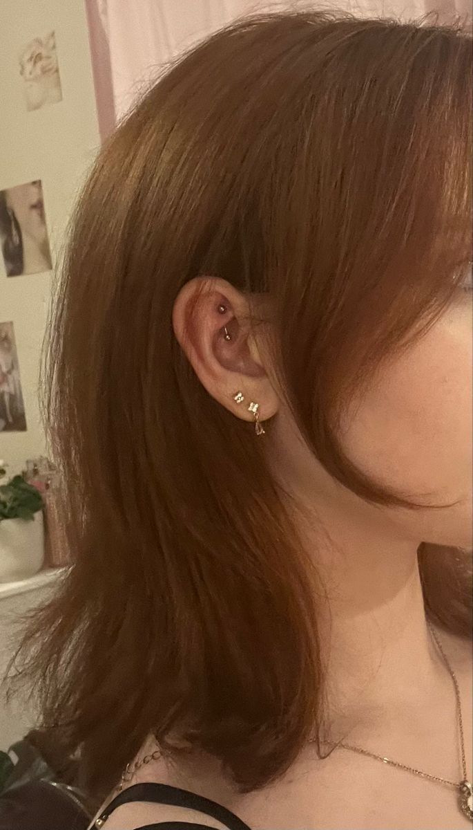 a close up of a person with ear piercings on their ears and wearing a black top