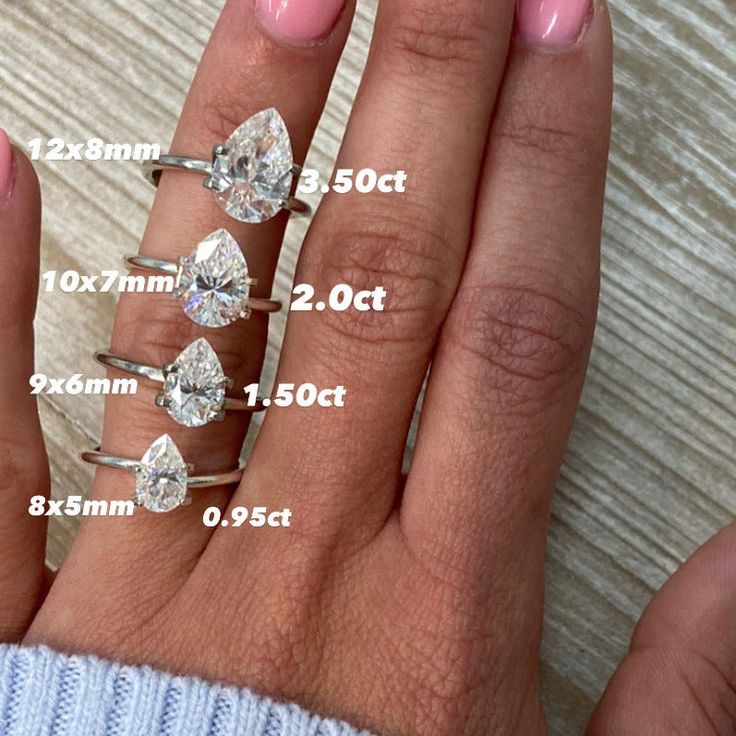 a woman's hand with five different sized diamonds on it and the measurements for each ring