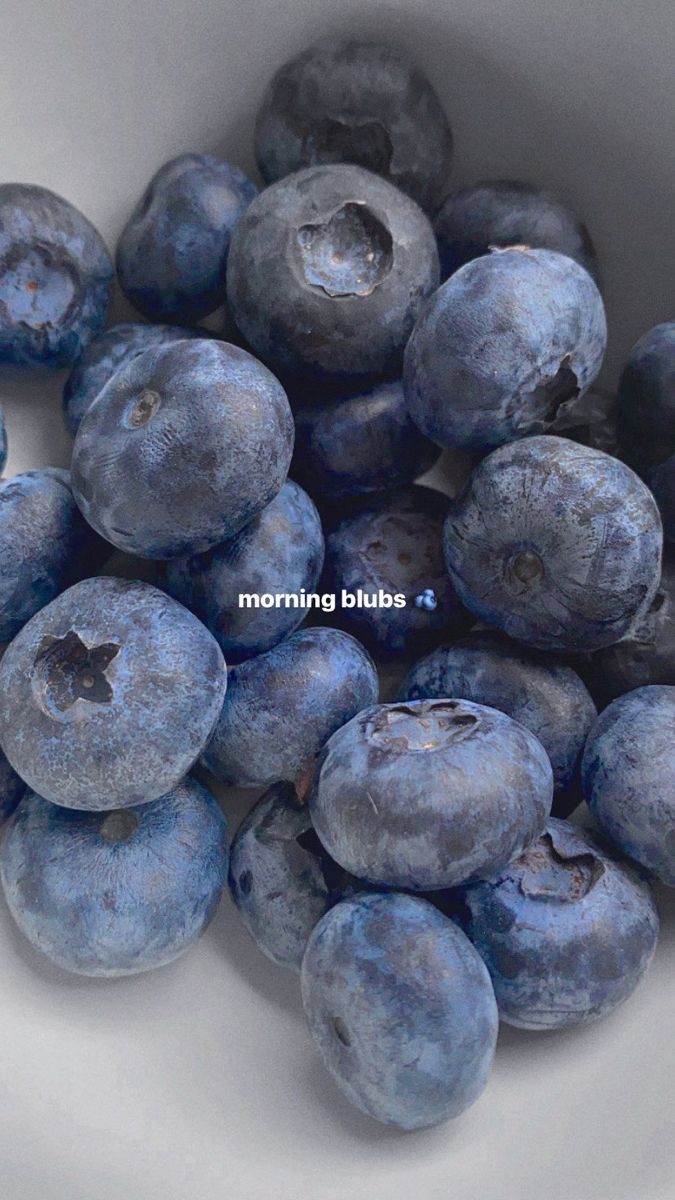 blueberries are in a white bowl on the table