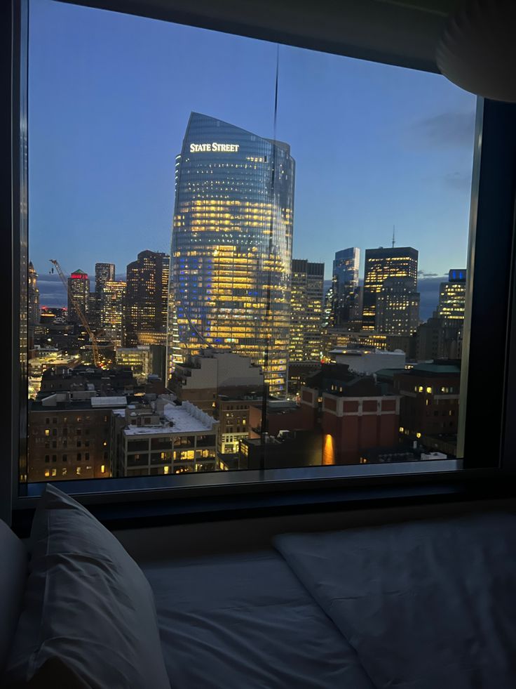 a view of the city at night from a hotel room window