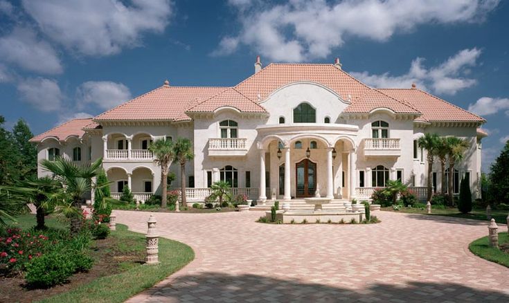 a large white house surrounded by palm trees