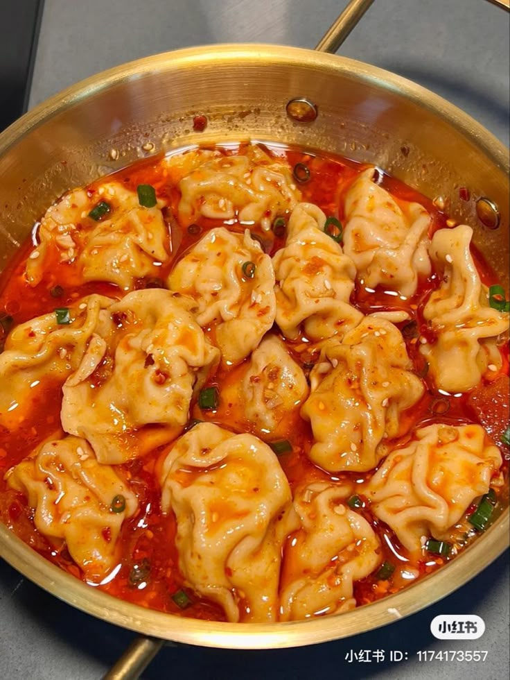 some dumplings are being cooked in a pan on the stove with chopsticks