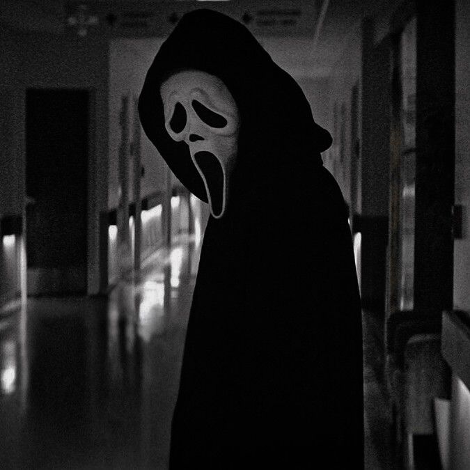 a person with a mask on in a hallway