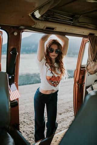 a woman standing in the open door of a vehicle