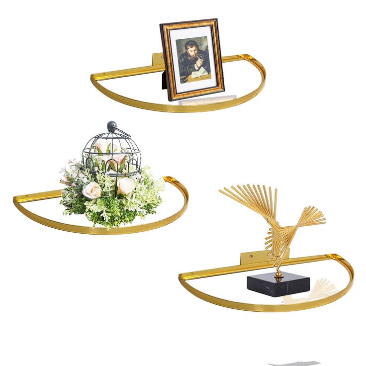 two gold shelves with pictures and flowers on them, one holding a birdcage