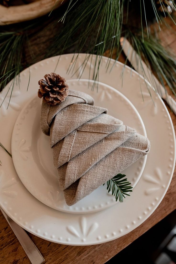 a white plate topped with a christmas tree shaped napkin on top of a wooden table