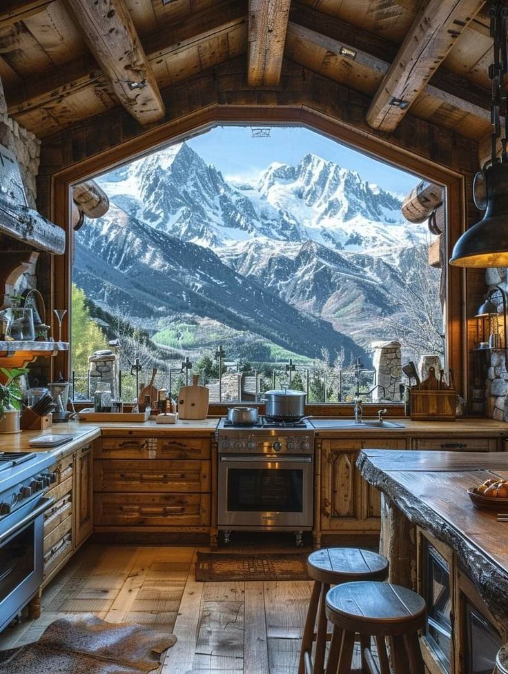 a kitchen with mountains in the background and an oven on the counter top, surrounded by stools