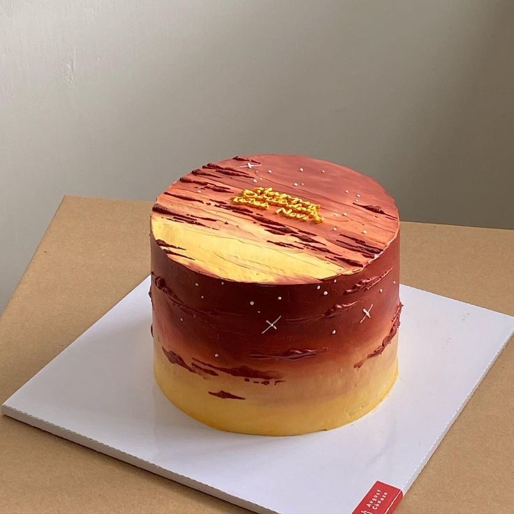 a cake that is sitting on top of a white plate with red and yellow frosting