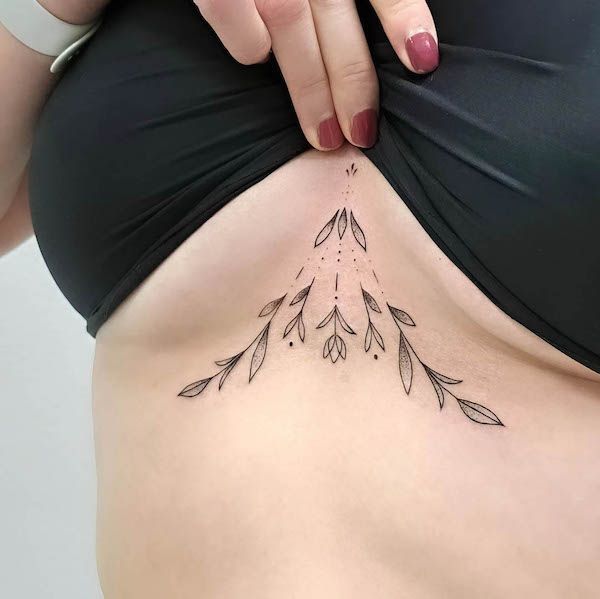 a woman's stomach with an arrow tattoo on her belly and the lower part of her abdomen