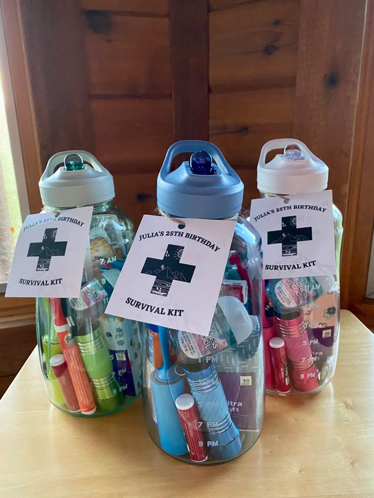 three jars filled with toothbrushes and personal care items sitting on top of a table