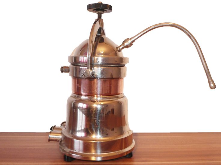 a coffee pot sitting on top of a wooden table next to a metal faucet