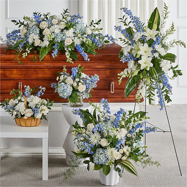 blue and white flowers are arranged in front of a casket