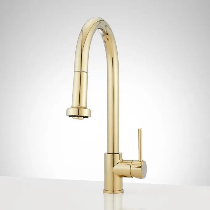 a gold faucet on a white counter top