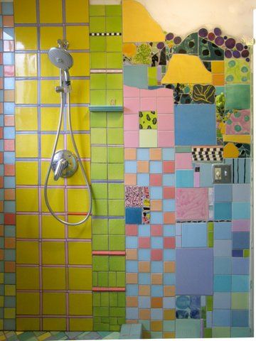 a bathroom with colorful tiles on the wall and shower head in the corner, next to a toilet