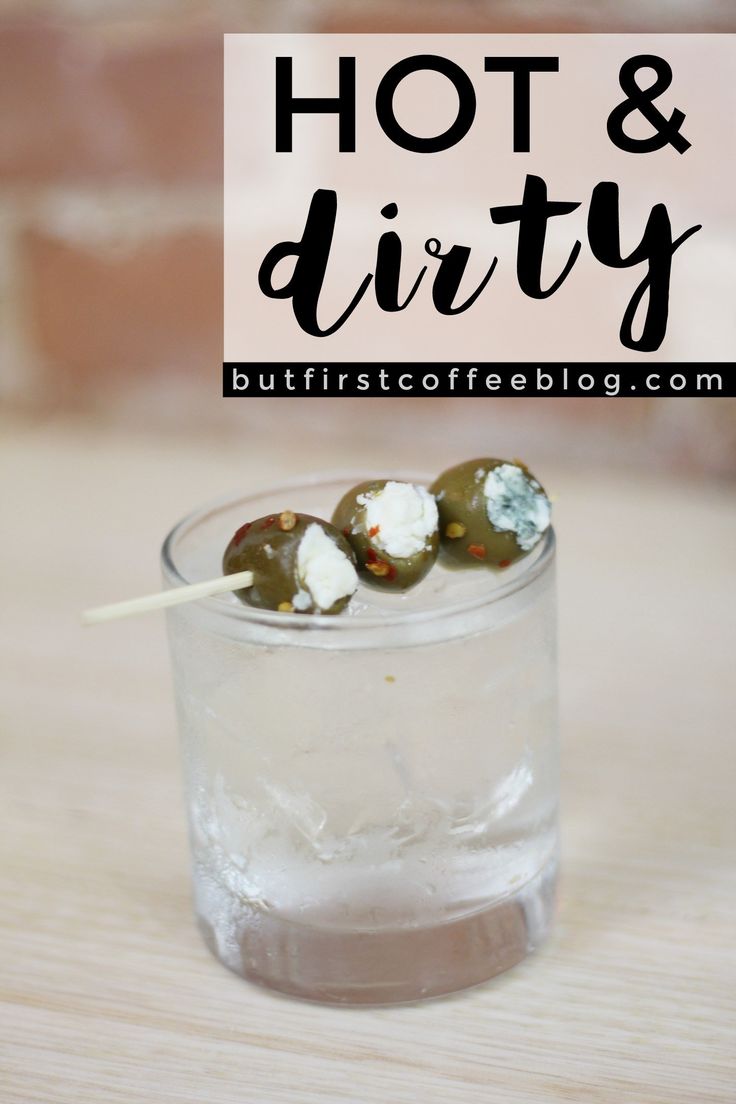 a glass filled with water and marshmallows on top of a wooden table