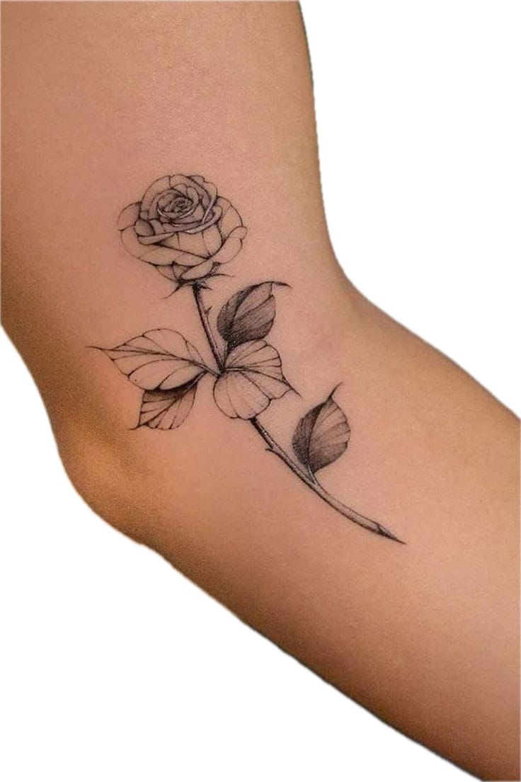 a small rose tattoo on the side of a woman's foot, with leaves