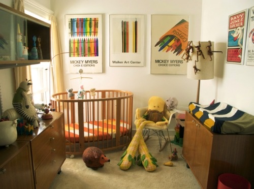 a baby's room with a crib, toys and pictures on the wall