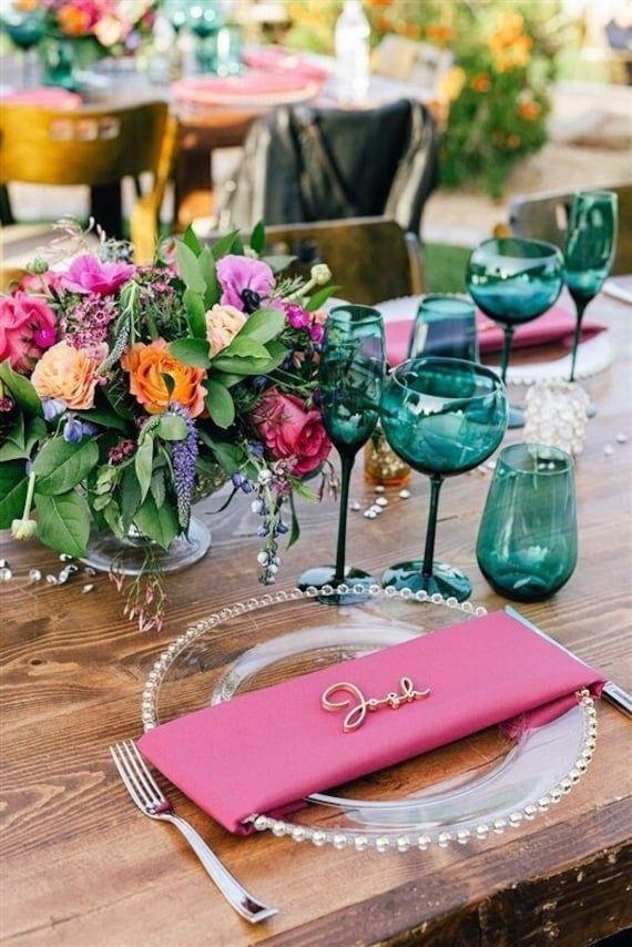 the table is set with pink and green place settings